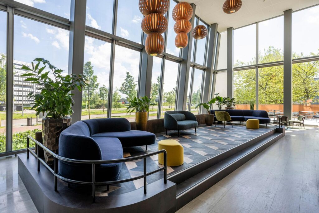 Moderne lounge met designmeubels en grote raampartijen aan de David Ricardostraat.